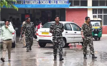  ??  ?? Indian security forces walk inside the government school where a seven year- old girl student was sexually assaulted, in New Delhi. — AFP photo