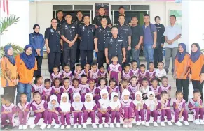  ??  ?? GURU dan murid-murid tadika dari Kampung Landung Ayang bersama empat guru bergambar kenangan dengan Douglas (tengah) dan para pegawai serta anggota polis lain.