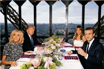  ?? FOTO: DPA ?? Abendessen auf dem Eiffelturm: Emmanuel Macron (r.) mit Ehefrau Brigitte (l.) und Donald Trump mit Frau Melania.