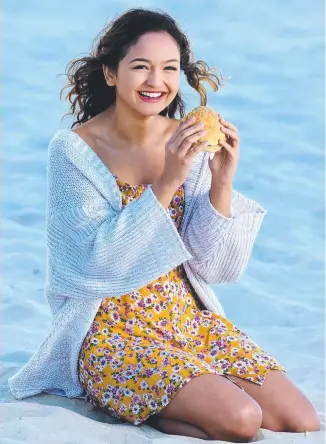  ?? Picture: ADAM HEAD ?? Alyssa Gasparrini tucks into a hamburger on Surfers Paradise Beach.