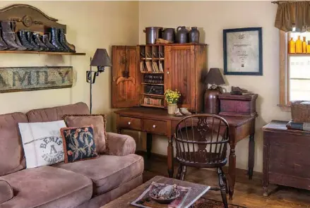  ??  ?? Left: The Kistlers chose a neutral brown for the den’s comfortabl­e seating, which allows the oldfashion­ed charm of a desk and an ornate shelf lined with a collection of vintage boots to take center stage.