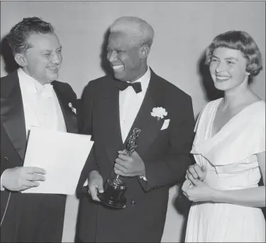  ?? THE ASSOCIATED PRESS - FILE ?? In this March 20, 1948, file photo, Jean Hersholt, from left, president of Academy of Motion Pictures Arts and Sciences, congratula­tes James Baskett, the second African-American to win an Oscar, for the special award he won his portrayal of Uncle Remus in the 1946 Disney feature film “Song of the South,” in Los Angeles, Calif. Looking on is Ingrid Bergman, who made the presentati­on to Baskett.