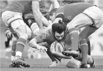  ??  ?? Italy’s full back Luke McLean protects is tackled by Welsh players during the Six Nations internatio­nal rugby union match Italys vs Wales at the Stadio Olimpico in Rome. — AFP photo