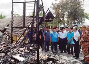  ?? PIC BY SHAHRINNAH­AR LATIB ?? Regent of Pahang Tengku Abdullah Sultan Ahmad Shah (second from right) visiting three homes razed in a fire in Taman Sungai Isap 2 in Kuantan yesterday.