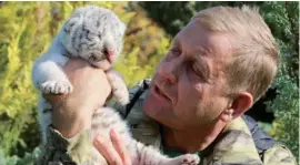  ?? — Reuters ?? Taigan Safari Park director Oleg Zubkov holds a one-week-old White Bengal tiger cub at the park near Belogorsk, Crimea, on Tuesday.