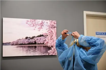  ?? Photograph: Chip Somodevill­a/Getty Images ?? A healthcare workers puts on a sterile gown while helping test patients for coronaviru­s in Virginia.