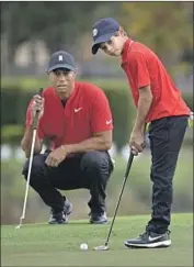  ?? Phelan M. Ebenhack Associated Press ?? TIGER WOODS watches son Charlie putt on the 18th green during last year’s PNC Championsh­ip.
