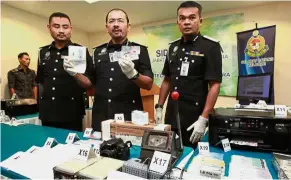  ??  ?? Imitation stuff: Mustafar (centre) and his officers showing the fake documents seized from the syndicate during the press conference at the Kuala Lumpur Home Ministry Complex.