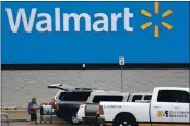  ?? JULIO CORTEZ — THE ASSOCIATED PRESS FILE ?? On March 31, a woman pulls groceries from a cart to her vehicle outside of a Walmart store in Pearl, Miss.