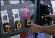  ?? MARTA LAVANDIER — THE ASSOCIATED PRESS ?? A customer pumps gas at an Exxon gas station in Miami. Gasoline prices are sliding back toward the $4mark for the first time in more than five months — good news for consumers who are struggling with high prices for many other essentials.