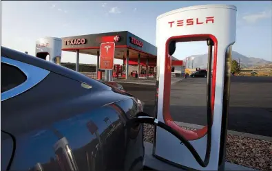  ?? Bloomberg/GEORGE FREY ?? A Tesla recharges at a Supercharg­er station in Nephi, Utah, in 2015. A Tesla Supercharg­er station is being built at the Outlets of Little Rock — becoming the only Supercharg­er site in the state.