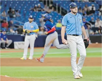  ?? STEVE NESIUS, AP ?? Tampa Bay Rays’ Luke Raley walks behind the mound after giving up a grand slam to Toronto Blue Jays’ Vladimir Guerrero Jr., centre, during the ninth inning on Tuesday.