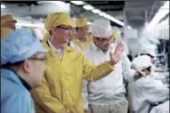  ?? AP photo ?? Apple CEO Tim Cook, center, visits the iphone production line at the newly built manufactur­ing facility at Foxconn Zhengzhou Technology Park, which employs 120,000 people.