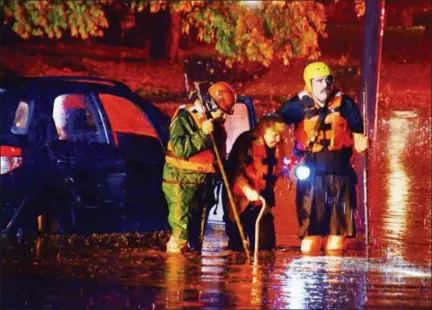  ?? TOM KELLY III — FOR DIGITAL FIRST MEDIA ?? Firefighte­rs from Goodwill Rescue and the Pottstown Fire Department rescue 86-year-old Lorraine Rega from her flooded car on East High Street near Roland Street after a severe storm struck the area Friday night, dumping heavy rain and causing flooded streets.