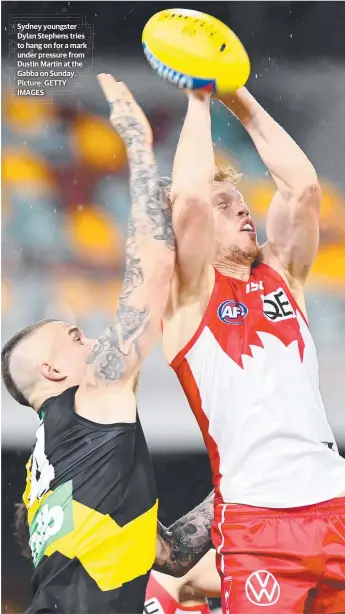  ??  ?? Sydney youngster Dylan Stephens tries to hang on for a mark under pressure from Dustin Martin at the Gabba on Sunday. Picture: GETTY IMAGES