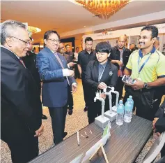  ??  ?? Abang Johari (second left) and Kadim (left) having a light moment with exhibitors at i-STEEx. — Photo by Chimon Upon