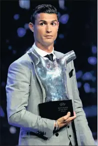  ??  ?? Real Madrid’s Cristiano Ronaldo holds the trophy after winning the UEFA Men’s Player of the Year Award in August.