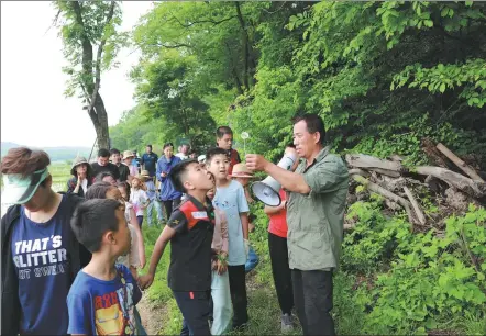  ?? PHOTOS PROVIDED TO CHINA DAILY ?? Li Rongfu (right) guide children and their parents during an ecological education tour in Jiaohe, Jilin province.