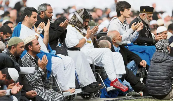 ?? — AP ?? Keeping the faith: Victims injured in the attack praying at Hagley Park in Christchur­ch.