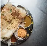  ?? Evan Sung photos / The New York Times ?? Rava dosa, a porous version with cashews, is served at Pai Brothers in Kochi. There, more millennial­s are choosing to eat out with foods familiar to them.