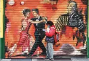  ?? (AFP) ?? A man wearing a face mask stands next to a mural in Buenos Aires recently.