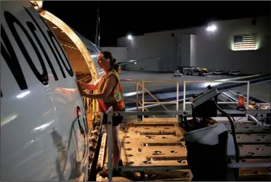  ?? Bloomberg News/LUKE SHARRETT ?? A worker finishes unloading a cargo jet at a UPS facility last week in Louisville, Ky. The shipping company had solid performanc­es in its internatio­nal and domestic package units in the second quarter.