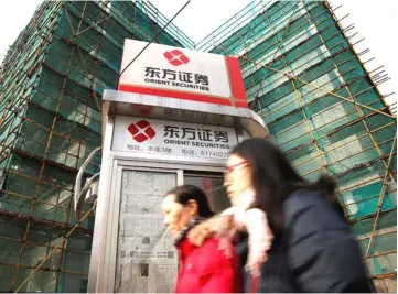  ??  ?? Logos of Orient Securities are seen near a branch of the company in Shanghai, China. — Reuters photos