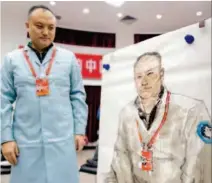  ??  ?? Space worker Li Haitao examines his portrait. ortrait. Li made important contributi­ons to China's 's lunar program.