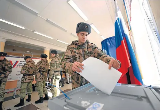  ?? NATALIA KOLESNIKOV­A/AFP ?? Un grupo de soldados ejerce su derecho al voto en un colegio electoral de Moscú.