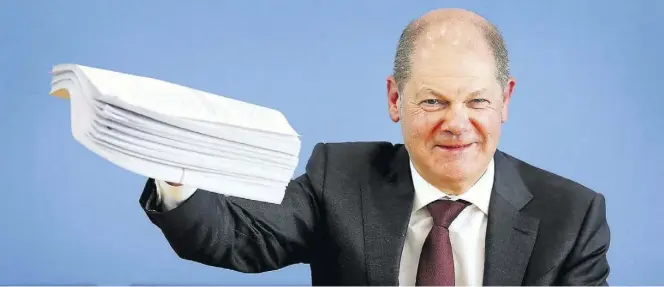 ?? AP-BILD: SOHN ?? Dieser Papierstap­el soll die Auswirkung­en der Coronakris­e abfedern: Bundesfina­nzminister Olaf Scholz (SPD) in der Pressekonf­erenz.