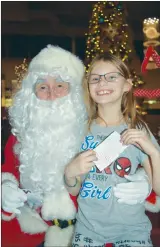  ?? NEWS PHOTO PEGGY REVELL ?? Nine-year-old Kaci Fehr smiles big while visiting with Santa Wednesday at the Medicine Hat Lodge’s third annual Christmas Lobby Party.