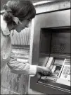  ?? AP FILE ?? In 1968, one year after the launch of the ATM, a woman puts her computer punch card into the slot of a machine outside a bank in central London.