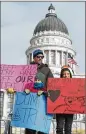  ?? RICK EGAN/THE SALT LAKE TRIBUNE ?? Perry Dixon, stands with his kids Miles, 6, and Parker 9, as they protest President Trump’s visit to Utah.