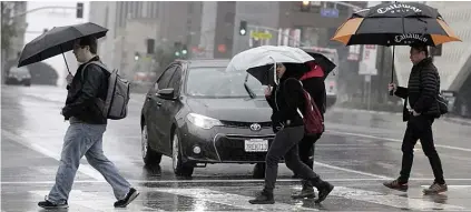  ?? AP FOTO ?? PEDESTRIAN­S cross a rainy street in downtown Los Angeles in February, 2017. According to a study released in April 2019 in the Bulletin of the American Meteorolog­ical Society, even light rain significan­tly increases the rise of a fatal car crash.