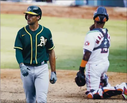  ?? PHOTOS BY MARCIO JOSE SANCHEZ — THE ASSOCIATED PRESS ?? The A’s Matt Olson, left, walks to the dugout after striking out against the Astros during the eighth inning of Game 4 of their American League Division Series in Los Angeles on Thursday. At right is Astros catcher Martin Maldonado.