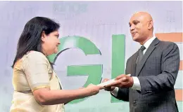  ?? ?? Prof. Dhammike Silva handing over the ‘GLEC Book’ to Dr. Shani de Silva.
Pix by Akila Jayawarden­a