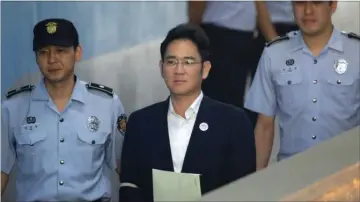  ?? Fotos: Lee Jin-man og Chung Sung-Jun/AP ?? Retssagen mod Sydkoreas ekspræside­nt Park Geun-hye vises på en stormskærm i Seoul. Nederst er det Samsungs fhv. næstforman­d Lee Jae-yong, som først fik en dom på fem års fængsel, men blev frikendt kort efter.