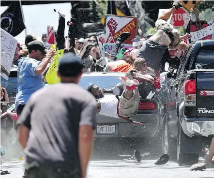  ?? — THE ASSOCIATED PRESS ?? People fly into the air as a vehicle drives into a group of protesters demonstrat­ing against a white nationalis­t rally in Charlottes­ville, Va., Aug. 12. The nationalis­ts were holding the rally to protest plans by Charlottes­ville to remove a statue of...