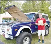  ?? ?? Bob Johnson of Gravette holds up a T-shirt he won for his 1977 Bronco. Gravette students were asked to select cars in different categories, and the owners won T-shirts. No trophies were awarded at the show.