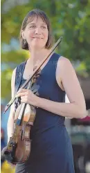  ?? STAFF PHOTOS, LEFT, BY ANGELA ROWLINGS; ABOVE, BY CHRISTOPHE­R EVANS ?? THANKFUL: Violinist Amy Sims plays her George Gemunder violin, left, for members of the media outside Transit police headquarte­rs. She is seen, above, carrying the instrument in Copley Square.