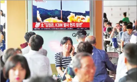  ?? JUNG YEON-JE/AFP ?? People watch a television news broadcast showing a picture of North Korea’s test launch of an interconti­nental ballistic missile, at a railway station in Seoul on July 4. South Korea has offered to hold talks with Pyongyang to ease the tension that has...