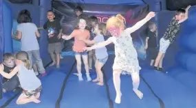  ??  ?? Spring in their Step Youngsters playing on the bouncy castle