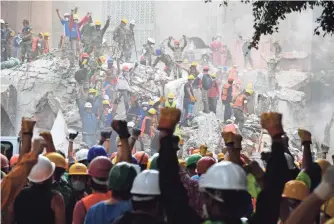  ?? AFP/GETTY IMAGES ?? Rescue workers signal for silence during the search for survivors in a flattened building in Mexico City, two days after a magnitude-7.1 earthquake rocked the country.