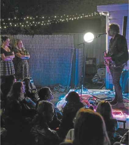  ??  ?? Singersong­writer Dan Kelly plays a private backyard gig.