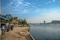  ?? AFP ?? Egyptians wait for a ferry to cross the Nile river on the island of Warraq in Cairo. —