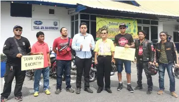  ??  ?? Teo (fourth left) shows the police report lodged at Miri Central station. Accompanyi­ng him are members of local motorcycle clubs and PKR Miri.