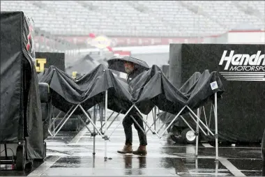  ?? GERRY BROOME — THE ASSOCIATED PRESS ?? A man walks through the infield as rain falls before a NASCAR Cup Series race at Charlotte Motor Speedway on May 27 in Concord, N.C.