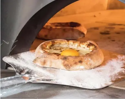  ?? (Wikimedia Commons) ?? GET IT while it’s hot: Adjarian khachapuri, boat-shaped with cheese, butter and egg yolk in the middle.