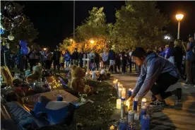  ?? Photograph: Apu Gomes/Getty Images ?? Andrea Tovar lights a candle at a vigil held for shooting victims on Sunday in Santa Clarita, California.