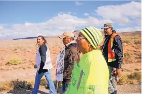  ??  ?? From left, Johannah Barber, Jerald Begay, Sarah Begay and Bobby Mason participat­e in an awareness walk organized by Walking the Healing Path along Navajo Route 13 in Red Valley, Ariz.